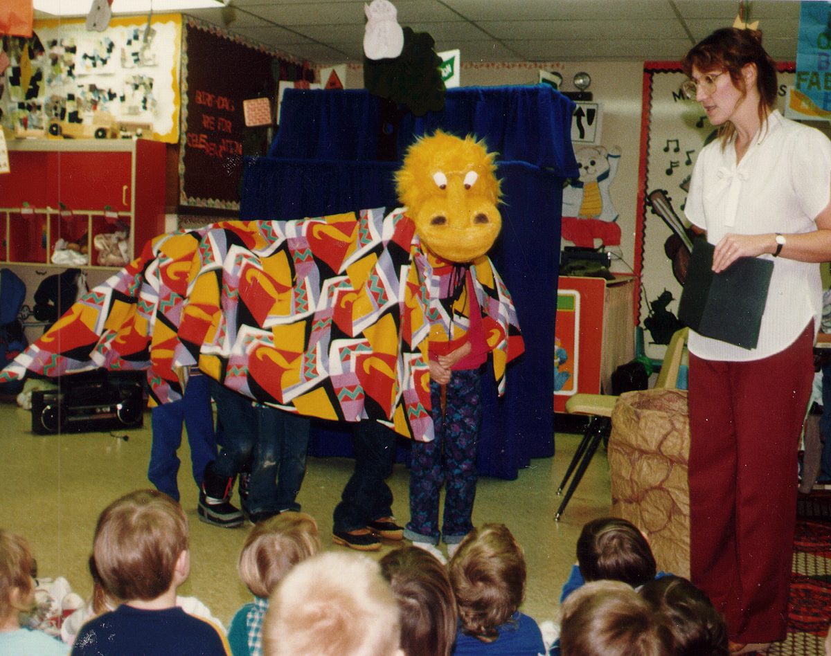 A young audience captivated during a Puppet Players show